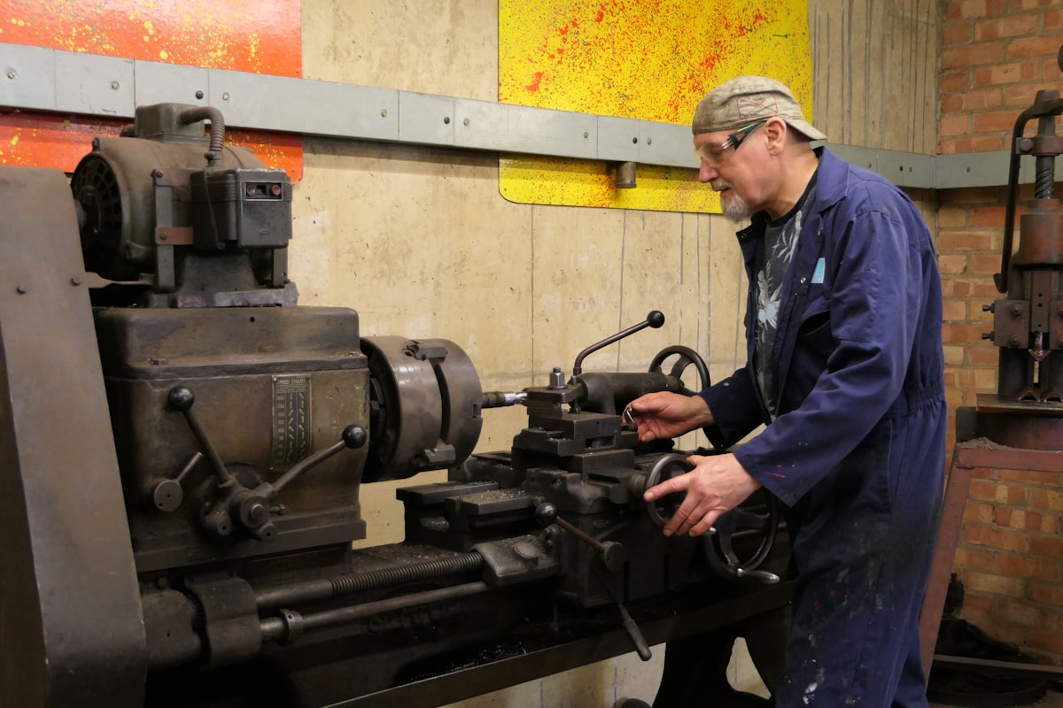 Machinist turning steel parts on a lathe